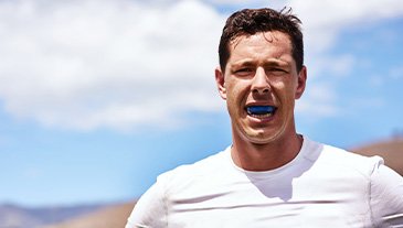 Man wears athletic mouthguard