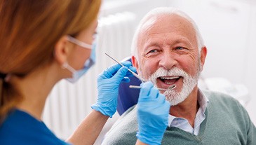 Man smiles at dentist