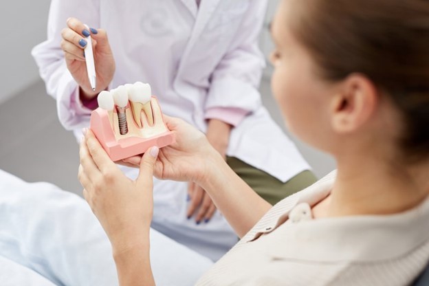 dentist showing model to dental implant candidate